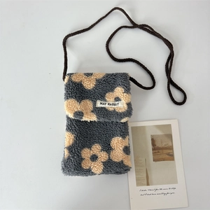 Détail du sac à bandoulière en peluche douce avec motif fleur jaune et sangle tissée