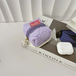 Detailed view of purple quilted earphone pouch with pearl zipper and rabbit tag label