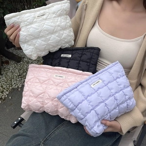 Close-up of quilted cosmetic bags in white black pink and purple with May Rabbit labels