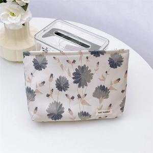 Detailed view of embossed sunflower jacquard fabric on a beige makeup storage bag
