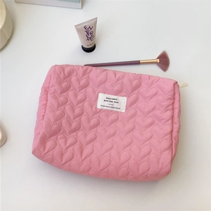 Detailed view of pink heart quilted fabric with secure zipper and brand woven label