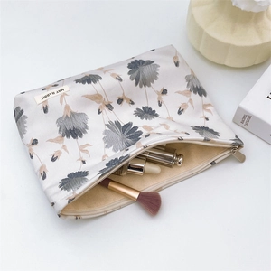 Floral jacquard cosmetic bag showing large interior capacity with makeup brushes