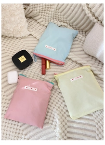 Pochettes en tissu de couleur macaron avec fermeture éclair sur une couverture tricotée