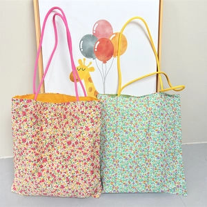 Detail view of large floral canvas tote bags with contrast lining and long handles