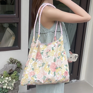 Dettaglio della borsa tote in cotone floreale con manico in corda intrecciata rosa
