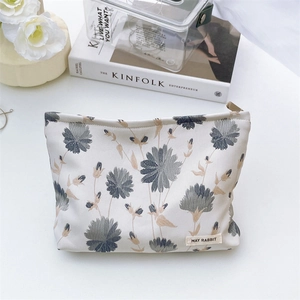 Close-up of floral jacquard fabric and brand label on large toiletry storage bag