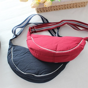 Detail of red and dark blue nylon dumpling bags with striped adjustable shoulder straps