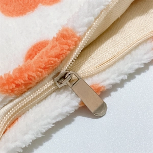 Close-up of cream nylon zipper and silver metal pull on plush floral bag