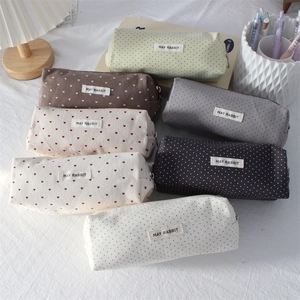 Close-up of heart and polka dot fabric pencil cases with May Rabbit woven labels