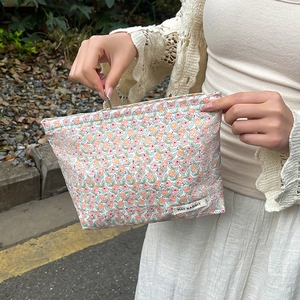 Close-up of floral makeup bag with metal zipper and May Rabbit brand label detail