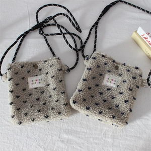 Detail of plush fleece crossbody phone bag with blue heart pattern and adjustable rope strap