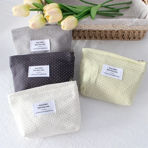 Set of four polka dot cosmetic bags with zippers in gray, black, beige, and yellow colors