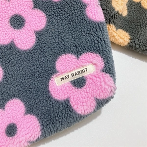 Close-up of soft grey faux-shearling fabric with plush pink flower patterns and texture