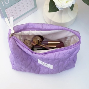 Detail of purple quilted makeup bag with heart pattern showing large storage capacity