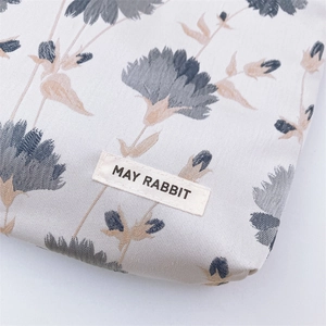 Macro shot of jacquard fabric texture and brand label on a floral cosmetic bag