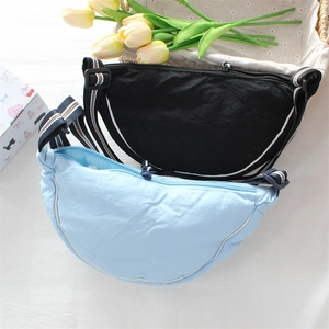 Detail of light blue and black crescent nylon bags with striped straps and white piping