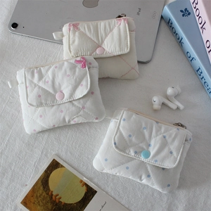 Detailed view of quilted cotton coin pouches in pink and blue dots with snap buttons