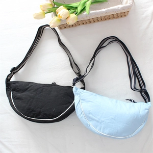 Detail of black and blue crescent crossbody bags with adjustable striped shoulder straps