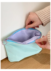 Detail view of macaron makeup bag showing mint green nylon and lavender lining texture