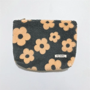 Detail of soft fleece floral makeup pouch with yellow daisy pattern and zipper