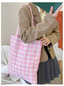Close-up of pink and white checkered canvas tote bag with embroidered pink bow detail