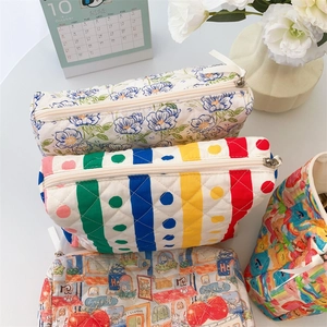Flat lay of quilted cotton cosmetic bags with floral, polka dot, and striped patterns