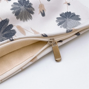 Close-up of golden metal zipper and embossed floral jacquard fabric on cosmetic bag