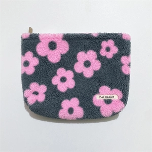 Macro detail of plush gray shearling texture with pink floral pattern and zipper