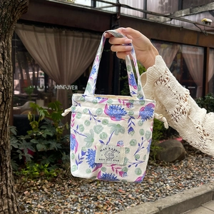 Close-up of floral pattern canvas bag with MAY RABBIT label and drawstring detail