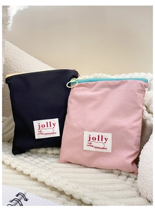 Détail de pochettes en nylon rose et noir avec anneaux de zip sur une couverture en maille