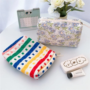 Close-up of quilted floral and rainbow stripe cotton cosmetic bags with zip closure