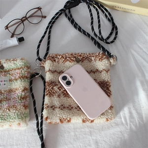Detail of plush fleece crossbody phone bag with striped pattern and woven rope strap