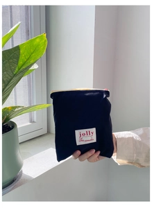 Détail du sac de rangement en tissu noir avec fermeture éclair et étiquette tissée