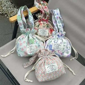 Floral drawstring canvas handbag collection with Rabbit label in outdoor setting