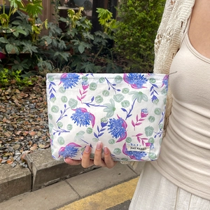 Floral print cotton makeup bag with MAY RABBIT label shown in a natural outdoor setting