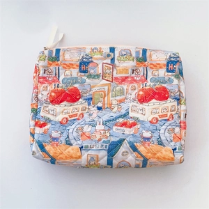 Macro view of quilted cotton cosmetic bag with village town illustration and zipper closure