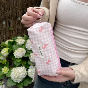 Close-up of pink checkered makeup bag with bow print and silver zipper pull