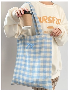 Detail of blue plaid canvas tote bag with delicate light blue bow embroidery