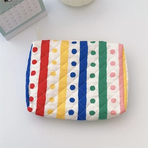Detail of colorful quilted cotton toiletry bag with stripes, dots, and a white zipper