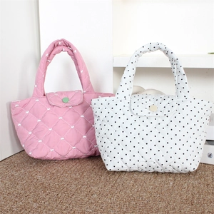 Detail view of pink and polka dot quilted tote bags with heart stitching and soft handles