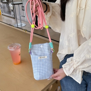 Detail of blue plaid phone bag featuring MAY RABBIT tag and pink braided strap cord