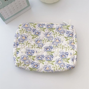 Close-up of quilted floral cotton makeup bag with blue and orange flower print and zipper