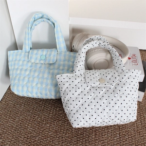 Detailed view of quilted tote bags featuring blue checks and heart polka dot patterns