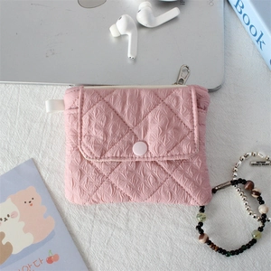 Detailed view of pink quilted mini storage pouch with snap button and silver metal zipper