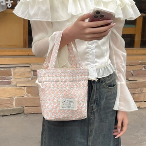 Detailed shot of floral canvas tote bag with drawstring closure and rabbit emblem