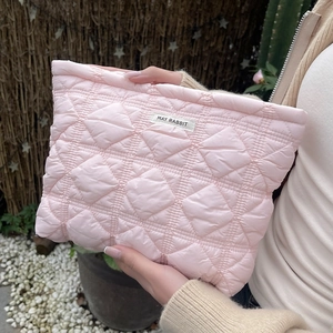 Detail of pink quilted cosmetic bag with diamond patterns and MAY RABBIT brand label