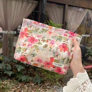 Detailed macro of floral pattern fabric storage bag with drawstring and brand label
