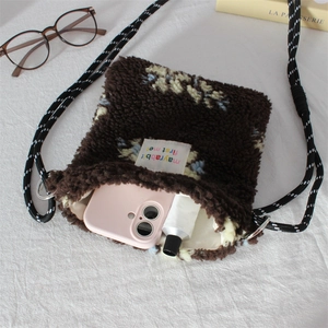 Detail of plush crossbody bag showing inner storage capacity for phone and cosmetics
