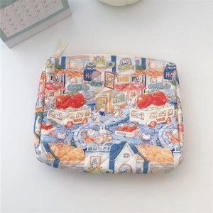 Detail of quilted floral cotton makeup bag featuring cute rabbit and cafe illustrations