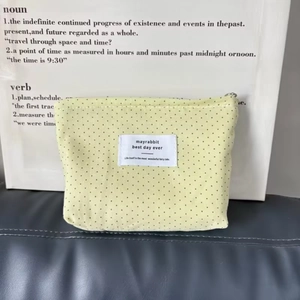 Macro detail of canvas makeup pouch with polka dots and silver zipper closure